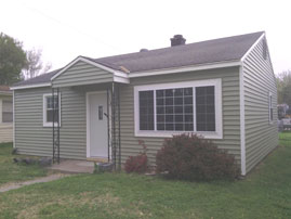 Coronet Window Company fixed picture window with sliders on either side and colonial grids.